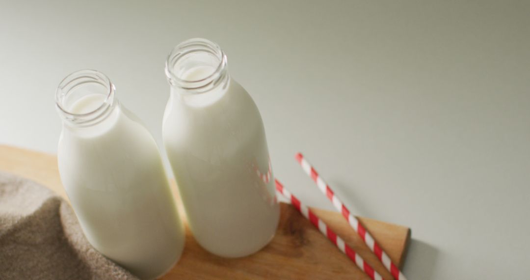 Fresh Milk Bottles with Striped Straws on Wooden Surface - Free Images, Stock Photos and Pictures on Pikwizard.com
