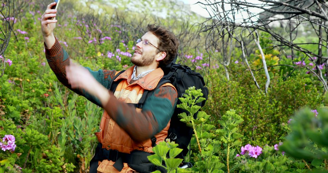 Man Taking Selfie During Hike in Flower-filled Forest - Free Images, Stock Photos and Pictures on Pikwizard.com