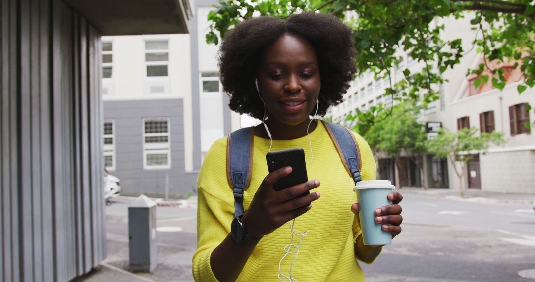 Smiling African Woman Walking in City Using Phone Drinking Coffee - Free Images, Stock Photos and Pictures on Pikwizard.com