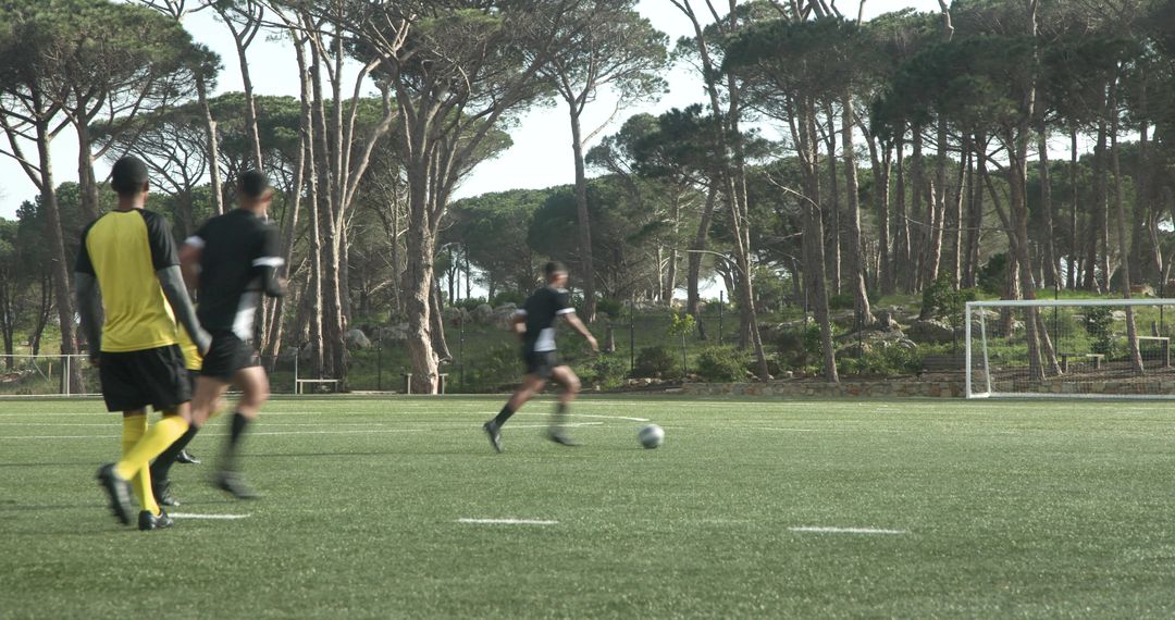 Soccer Players Practicing on Tree-Lined Field