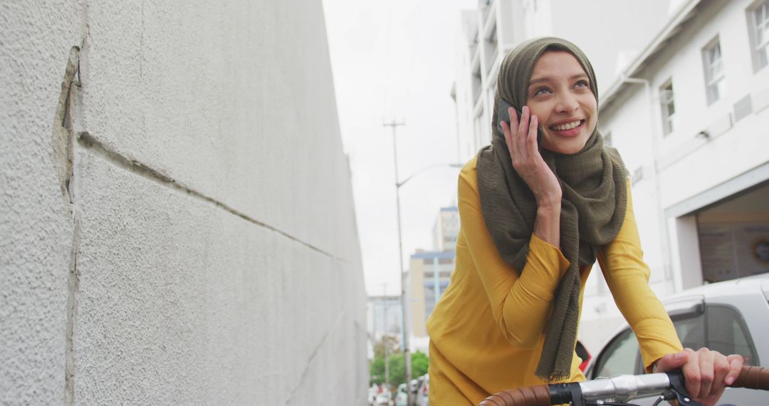 Happy Muslim Woman Riding Bike While Talking on Phone - Free Images, Stock Photos and Pictures on Pikwizard.com