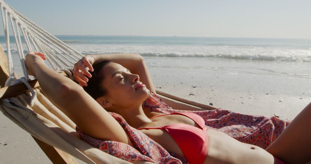 Relaxed Woman Sunbathing on Beach Hammock by Sea - Free Images, Stock Photos and Pictures on Pikwizard.com