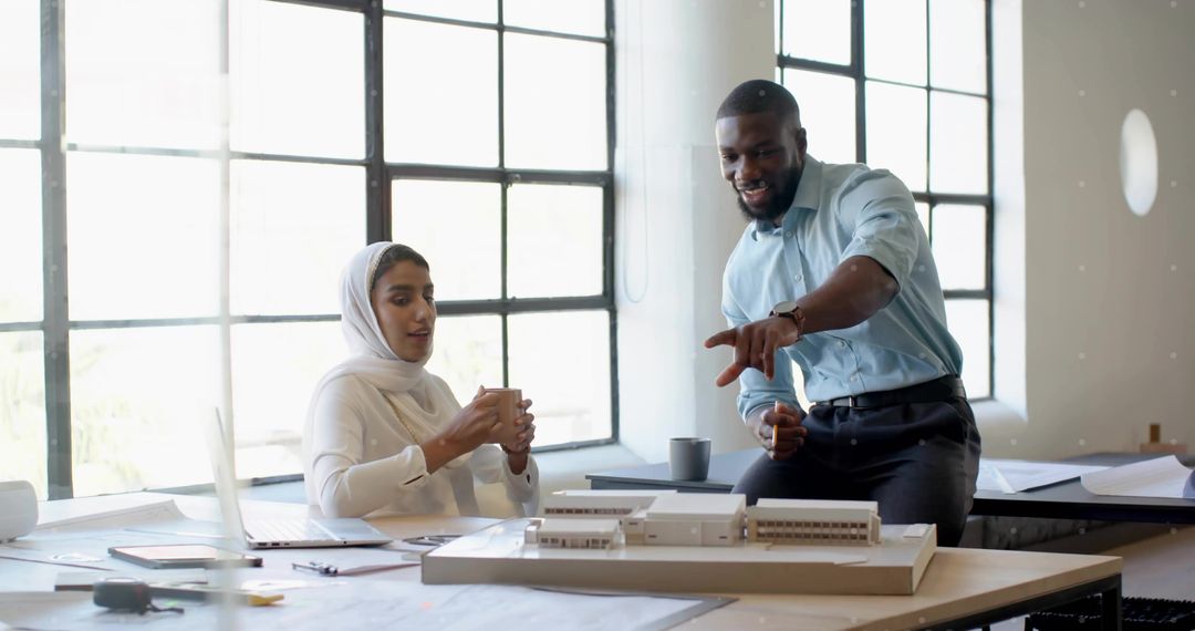 Architects Collaborating Over Scale Model at Design Studio Table