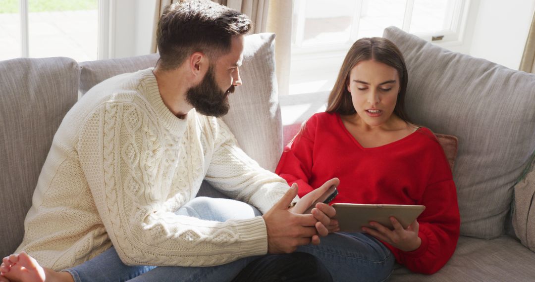 Couple Relaxing on Sofa Enjoying Digital Devices at Home