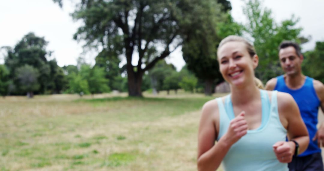 A young Caucasian woman and a man jog together in a park, with copy space - Free Images, Stock Photos and Pictures on Pikwizard.com