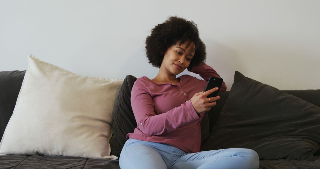 Relaxed African American Woman Using Smartphone on Comfortable Couch - Free Images, Stock Photos and Pictures on Pikwizard.com