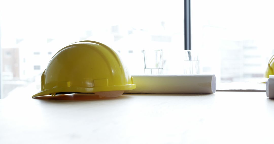 Yellow Hard Hat and Building Plans on Design Table at Construction Site - Free Images, Stock Photos and Pictures on Pikwizard.com