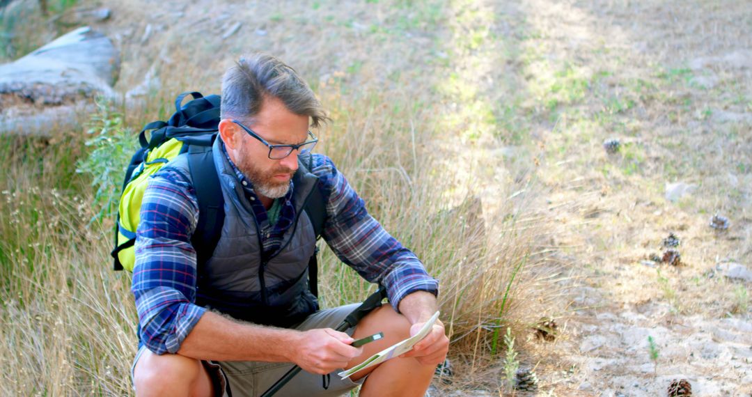 Man Navigating Trail with Map During Hike in Nature