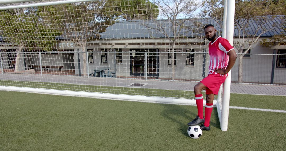 Confident Soccer Player Leaning on Goalpost