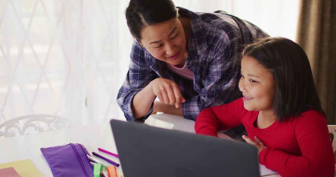 Joyful Mother and Daughter Learning Together at Home