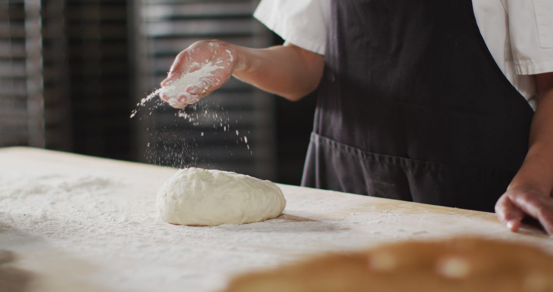 Baker sprinkling flour on dough during preparation - Free Images, Stock Photos and Pictures on Pikwizard.com