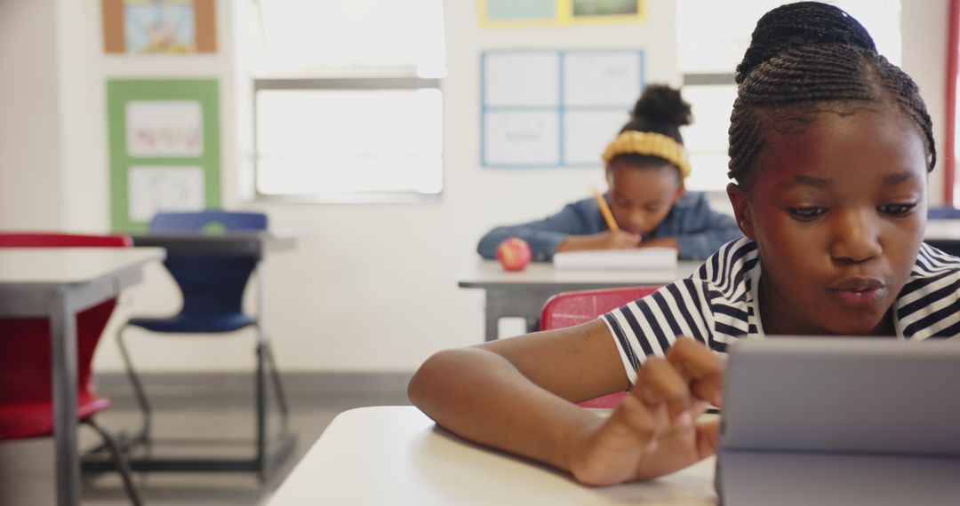 Focused African American Student Using Digital Tablet in Classroom