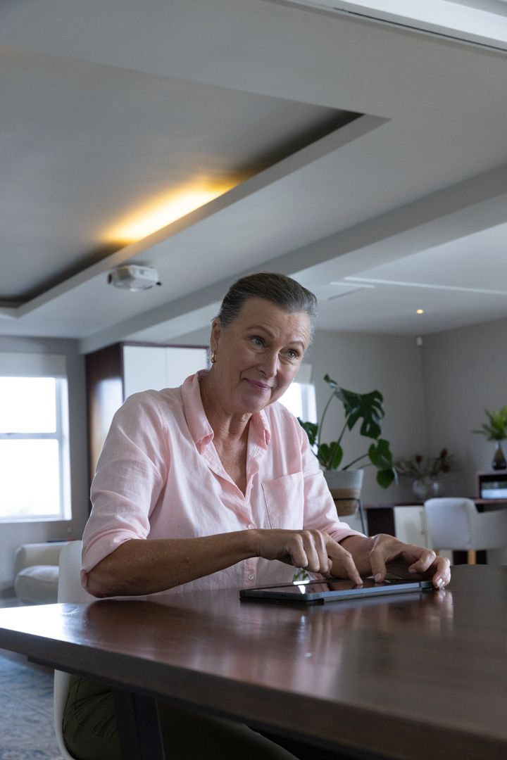 Elegant Senior Woman Using Tablet in Modern Living Room