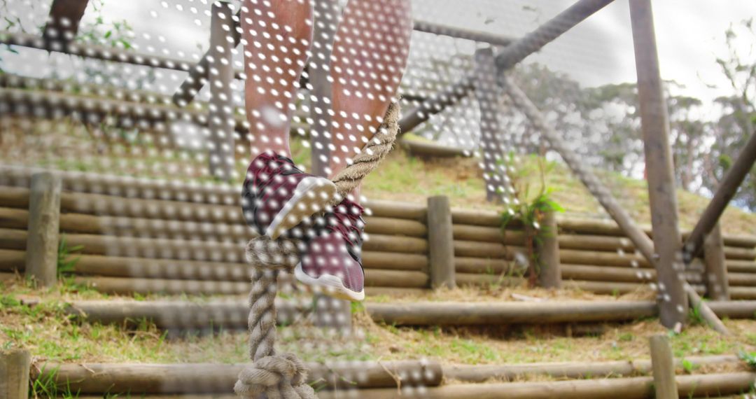 Climbing Knotted Rope on Outdoor Obstacle Course with Maroon Sneakers on Timber Steps