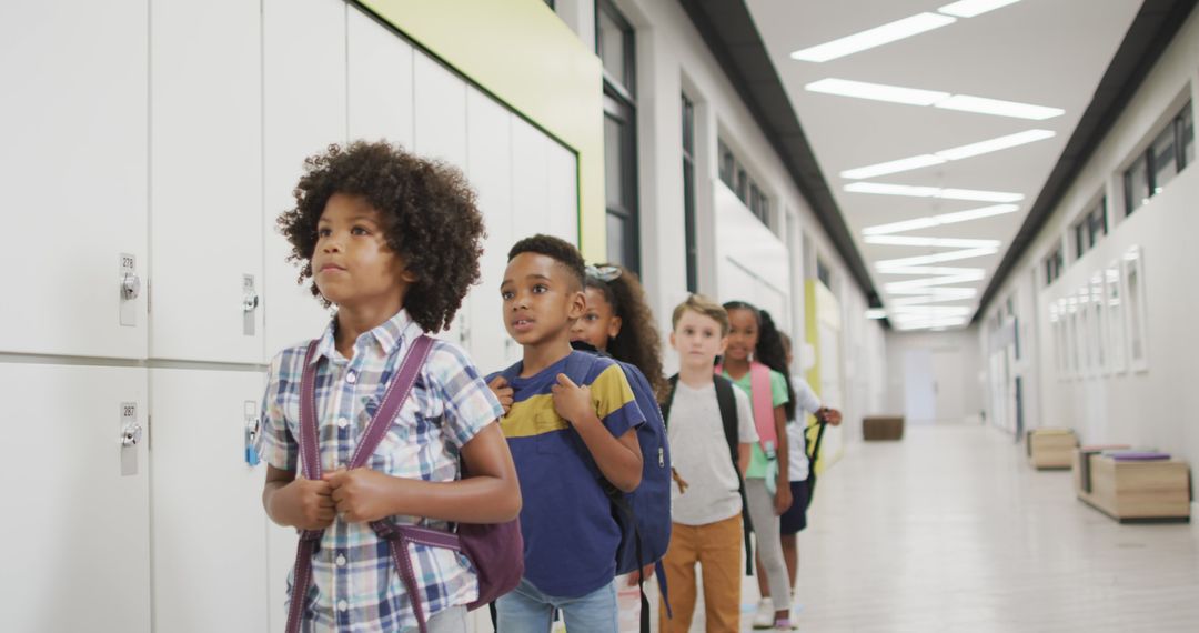 Diverse group of children with backpacks walking in school corridor - Free Images, Stock Photos and Pictures on Pikwizard.com