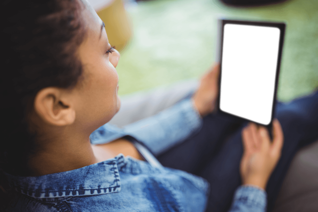 Woman in denim holding transparent tablet in park setting