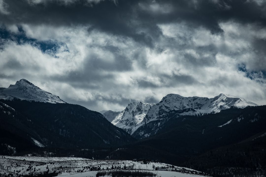 Dark Clouds Over Snow-Covered Mountain Peaks - Free Images, Stock Photos and Pictures on Pikwizard.com