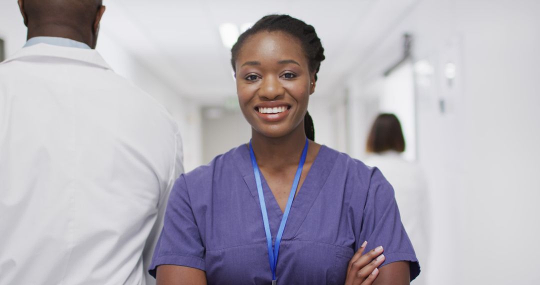 Confident Female Nurse Smiling in Hospital Corridor - Free Images, Stock Photos and Pictures on Pikwizard.com