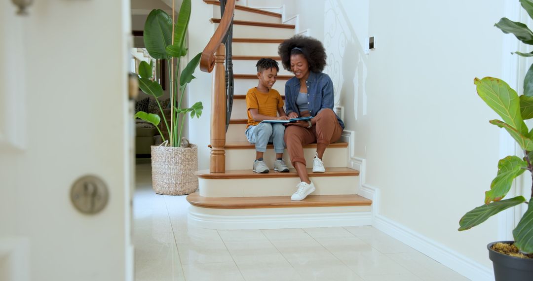 Mother and Son Reading on Staircase at Home