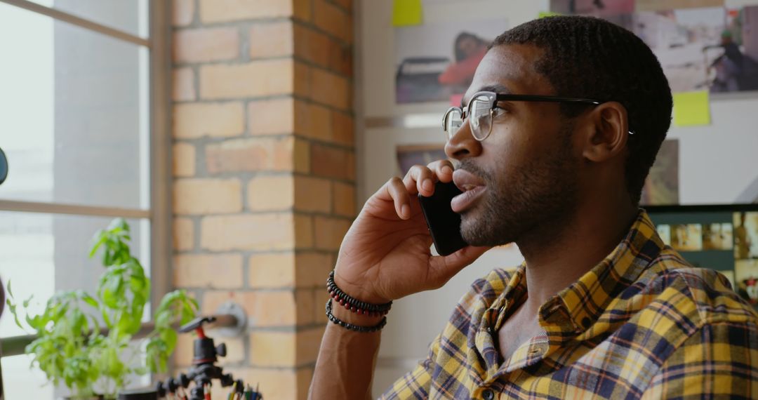 Creative Designer Engaged in Mobile Conversation at Office Desk