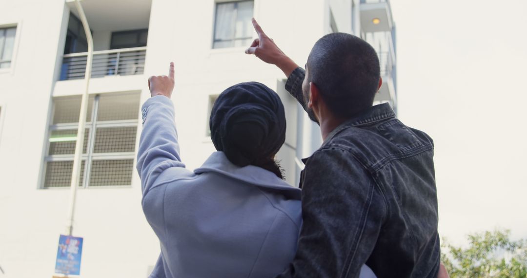 Couple Pointing at Apartment Building Together - Free Images, Stock Photos and Pictures on Pikwizard.com