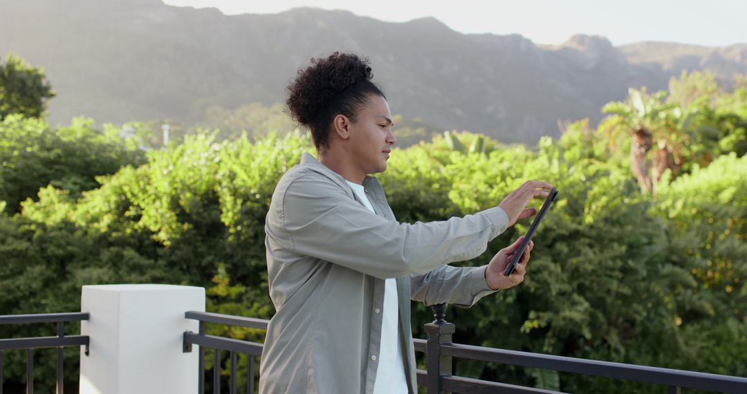 Man Enjoying Scenic Mountain View on Balcony in Tranquil Setting