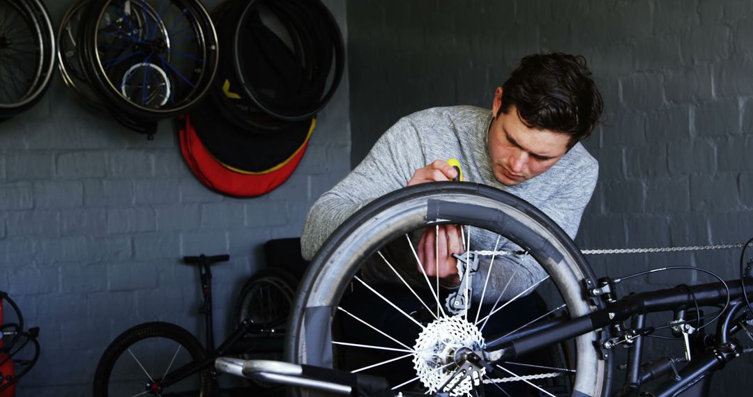 Young Man Repairing Bicycle Tire in Workshop - Free Images, Stock Photos and Pictures on Pikwizard.com