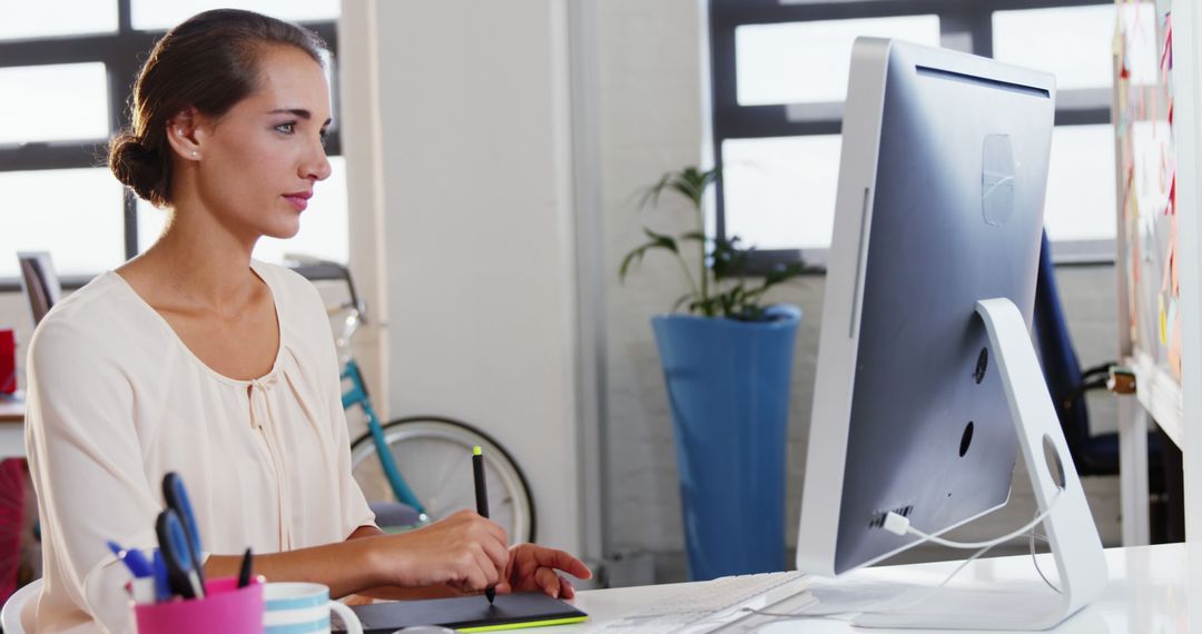 Woman Focusing on Work, Using Desktop Computer in Bright Office - Free Images, Stock Photos and Pictures on Pikwizard.com