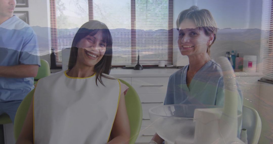 Smiling patient sitting in green dental chair with dental hygienist smiling and team working