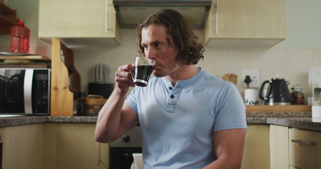 Man Drinking Cup of Coffee in Modern Kitchen - Free Images, Stock Photos and Pictures on Pikwizard.com