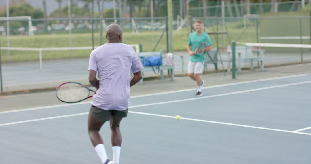 Two Men Playing Tennis Match in an Outdoor Court - Free Images, Stock Photos and Pictures on Pikwizard.com