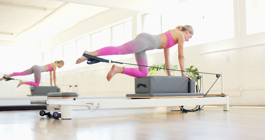 Woman Practicing Pilates on Reformer Machine in Bright Studio