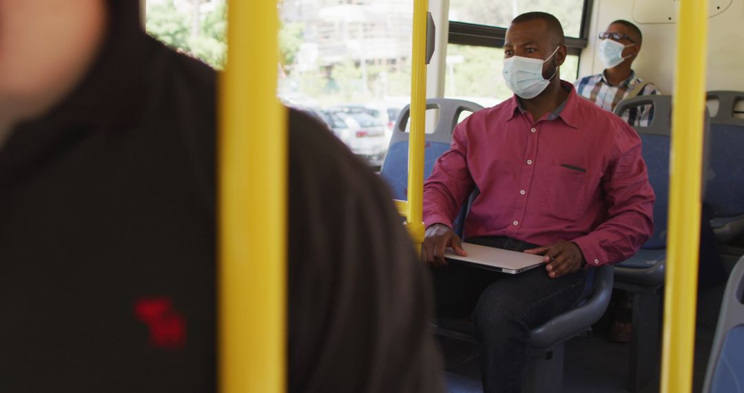 Businessman Commuting on Bus with Laptop During Pandemic