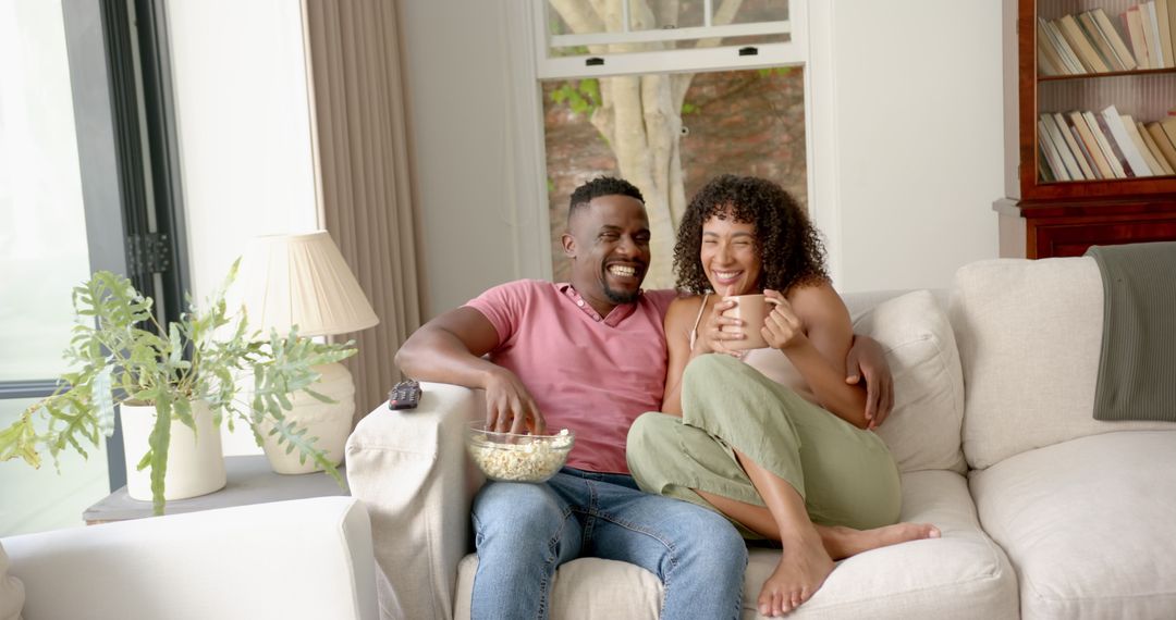 Happy Couple Relaxing with Popcorn and Coffee at Home