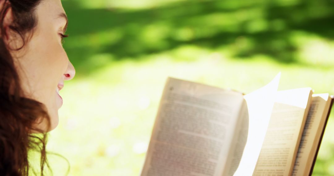 Woman reading book outside in sunny park - Free Images, Stock Photos and Pictures on Pikwizard.com