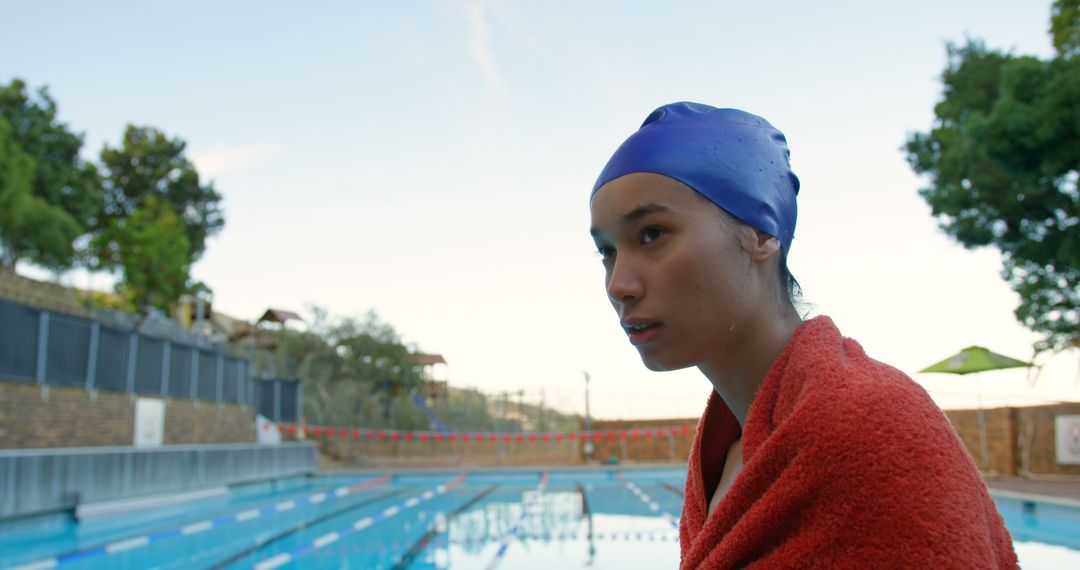 Contemplative Female Swimmer Poolside with Red Towel - Free Images, Stock Photos and Pictures on Pikwizard.com