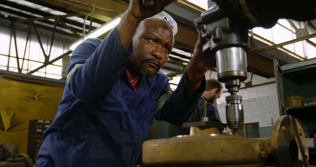 Focused African American Man Operating Industrial Drill Machine in Workshop - Free Images, Stock Photos and Pictures on Pikwizard.com