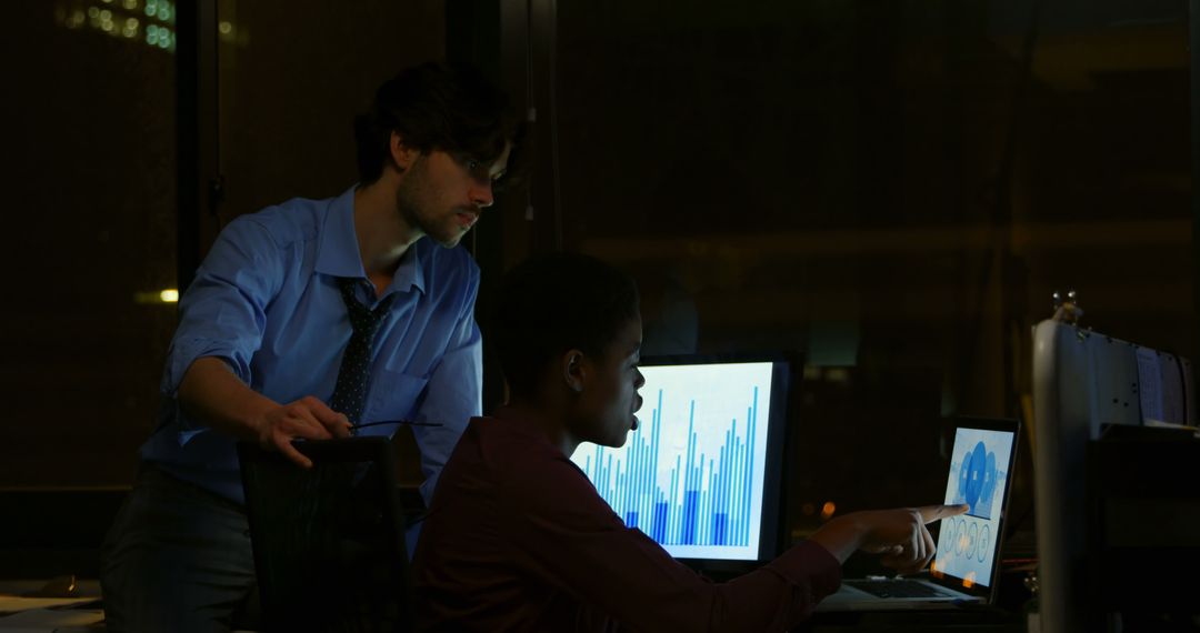 Business Colleagues Analyzing Data on Multiple Monitors at Night - Free Images, Stock Photos and Pictures on Pikwizard.com