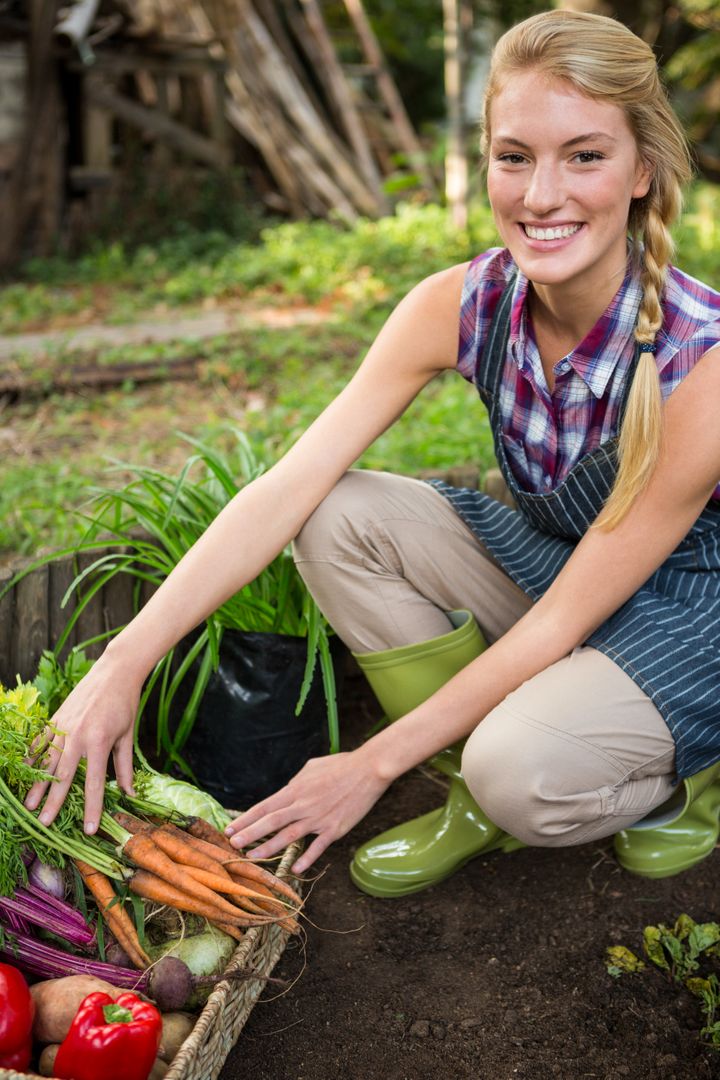 Portrait of beautiful gardener with fresh vegetables at garden - Free Images, Stock Photos and Pictures on Pikwizard.com