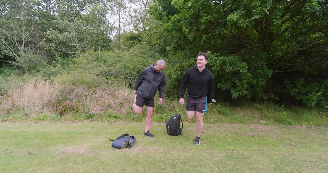 Two Men Stretching Before Jog in Green Park Setting