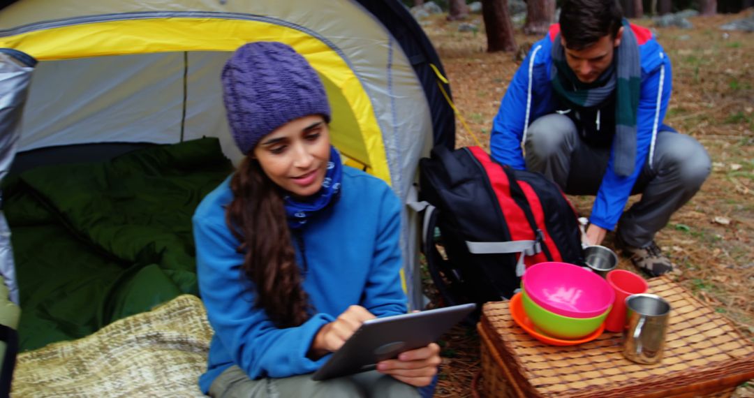 Young Campers using Tablet and Preparing Meal in Forest