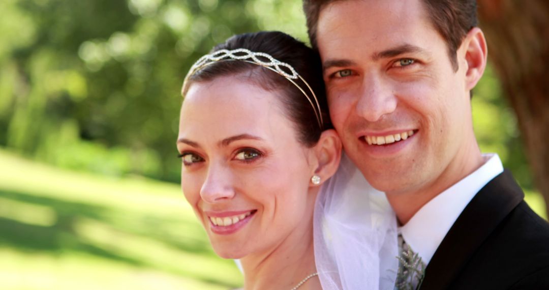 Smiling Newlyweds Embracing on Sunny Day in Nature - Free Images, Stock Photos and Pictures on Pikwizard.com