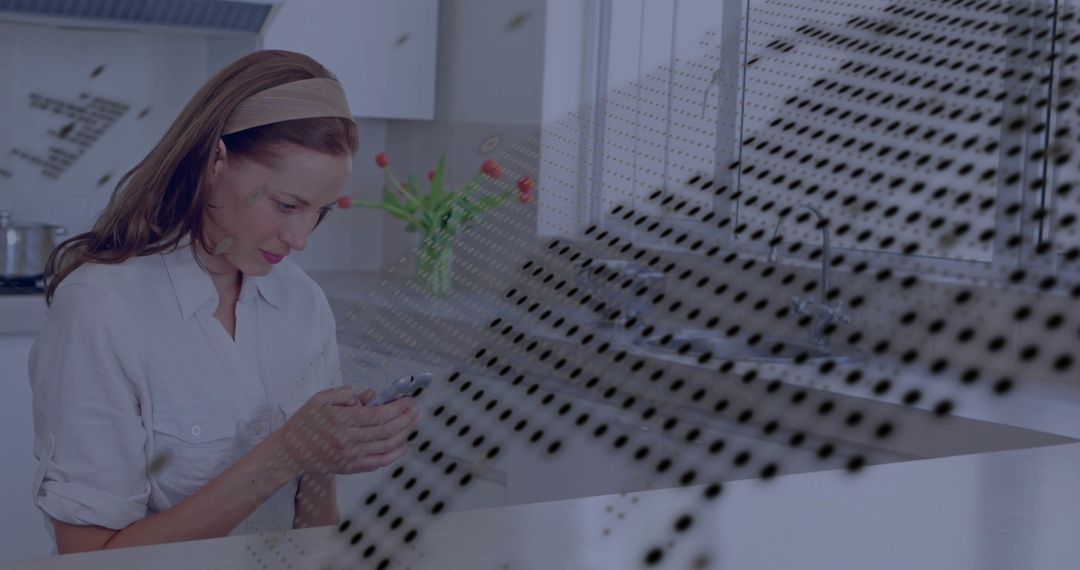 Woman Checking Smartphone in Modern Kitchen with Tulips on Counter