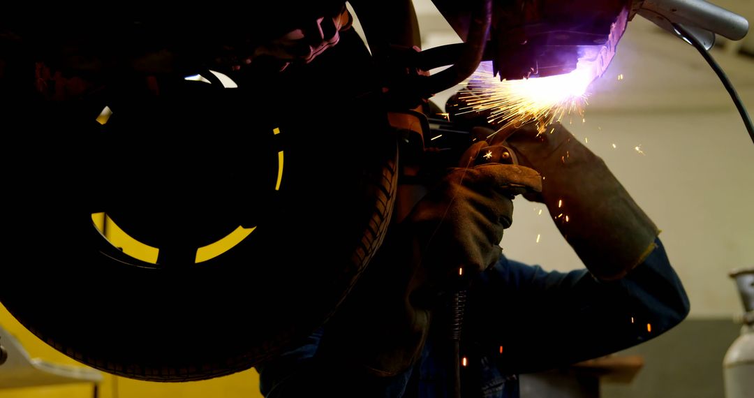 Mechanic Welding Car with Sparks Flying in Dark Workshop - Free Images, Stock Photos and Pictures on Pikwizard.com