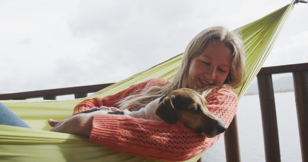 Woman Relaxing in Hammock with Dog by Waterfront - Free Images, Stock Photos and Pictures on Pikwizard.com