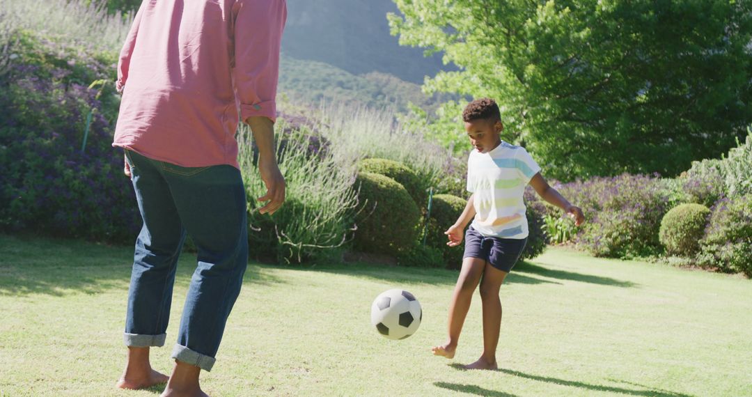 Father And Son Playing Soccer Outdoors In Sunny Garden - Free Images, Stock Photos and Pictures on Pikwizard.com