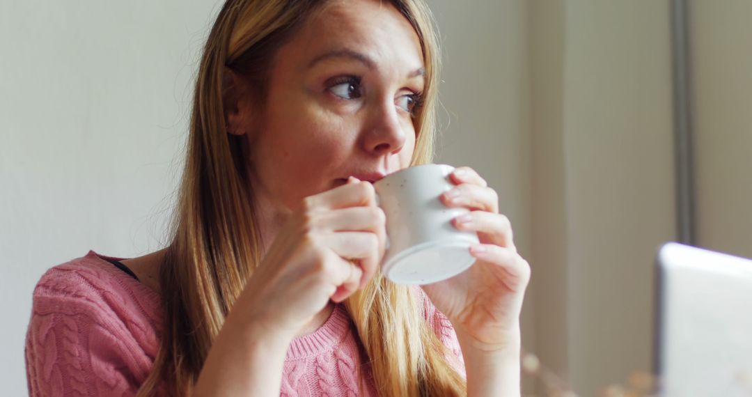 Woman Drinking Coffee and Looking Thoughtful Near Window - Free Images, Stock Photos and Pictures on Pikwizard.com