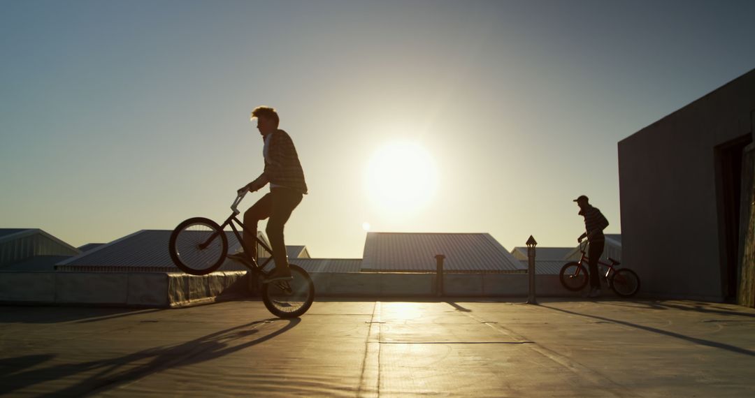 Silhouetted BMX Riders Performing Tricks During Sunset - Free Images, Stock Photos and Pictures on Pikwizard.com