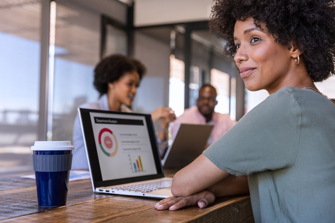 Diverse Colleagues Collaborating in Modern Office with Laptops and Coffee
