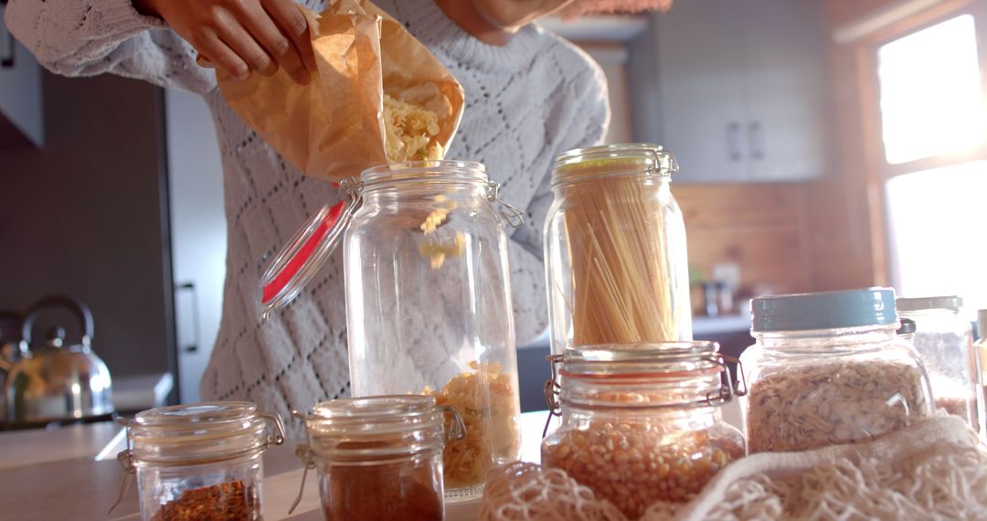 Person Storing Food in Eco-Friendly Kitchen Containers on Sunlit Counter - Free Images, Stock Photos and Pictures on Pikwizard.com